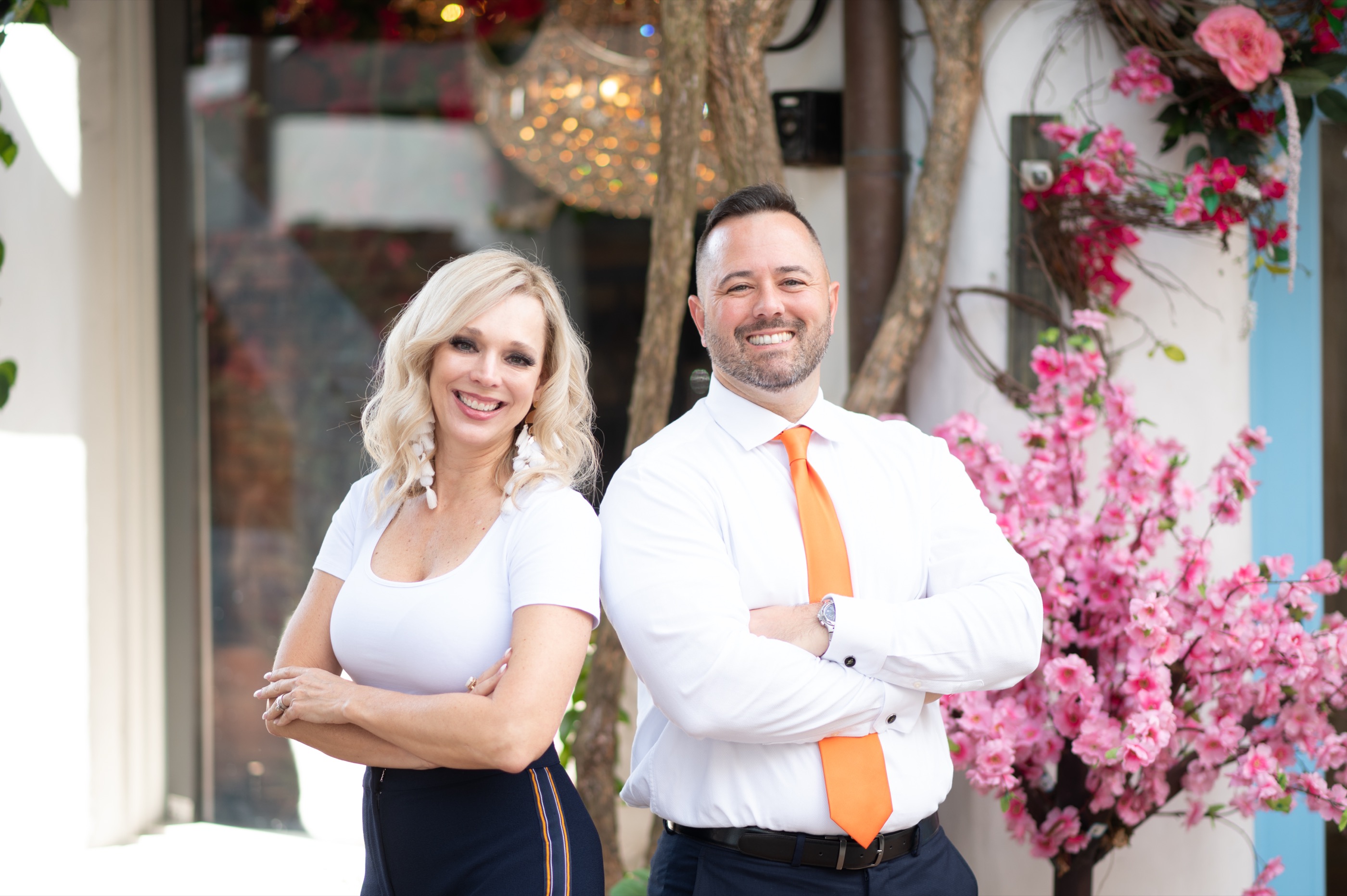 Matt and Jenn Freda, Central Florida real estate brokers, standing together outside
